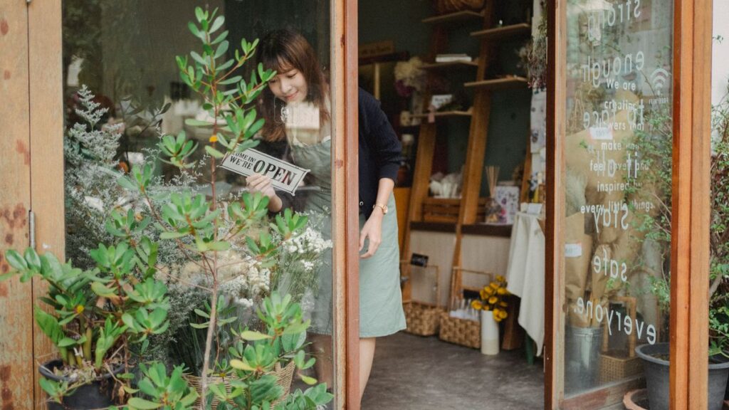 Florist turning the sign on her shop door to open