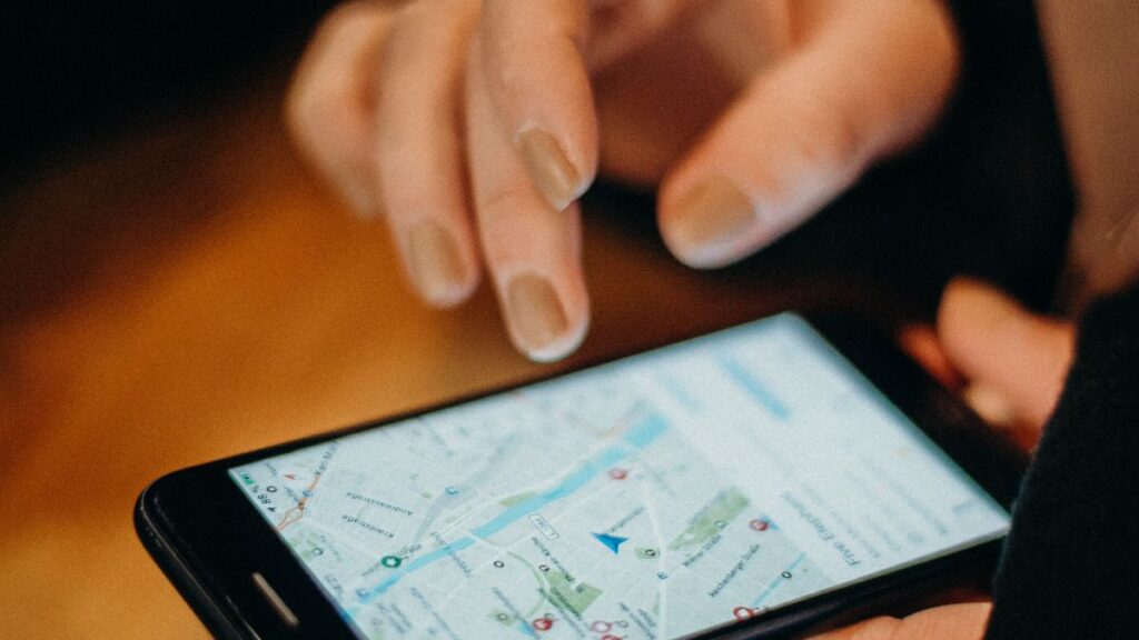 Person searching a map app on a smartphone for nearby businesses